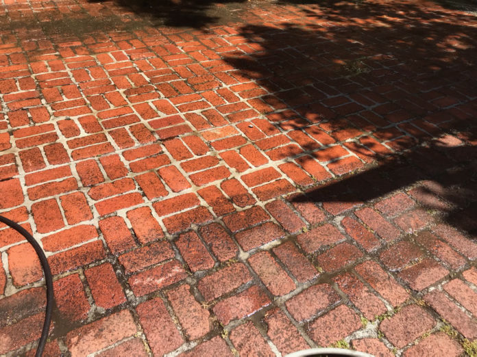 brick walkway being power washed